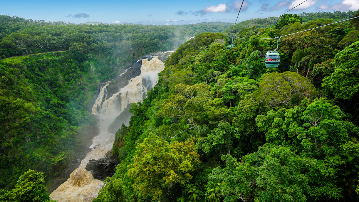 Kuranda Skyrail gliding over rainforest and waterfall in Cairns, Australia.