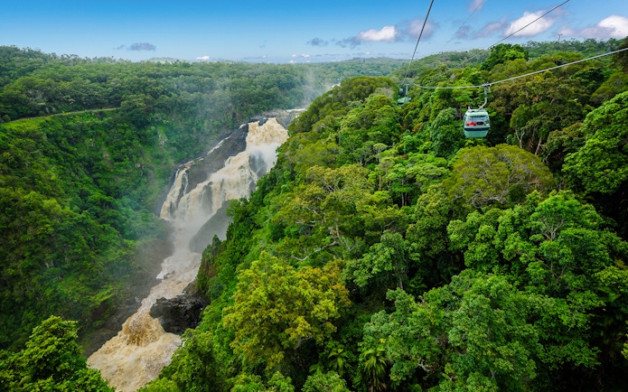 Kuranda Skyrail gliding over rainforest and waterfall in Cairns, Australia.