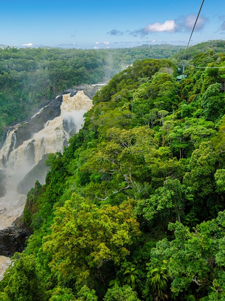 Kuranda Skyrail gliding over rainforest and waterfall in Cairns, Australia.