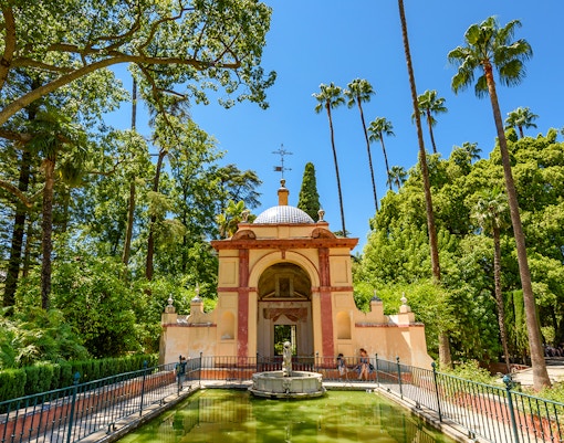 Patio de las Doncellas courtyard with reflecting pool at Seville Alcazar, Spain.