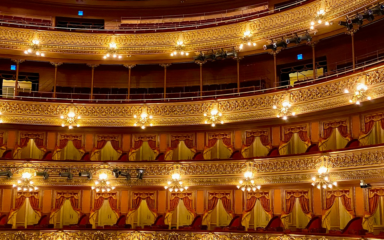 Teatro Colón ornate box seats with red curtains and golden details.
