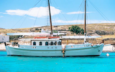 Guests swimming near a boat during a Corfu tour stop.