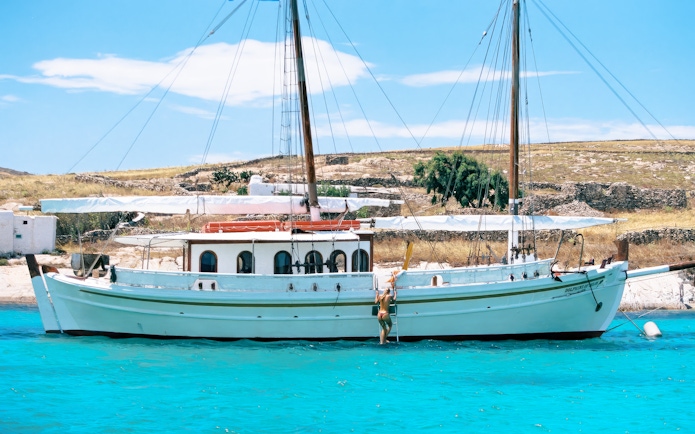 Guests swimming near a boat during a Corfu tour stop.