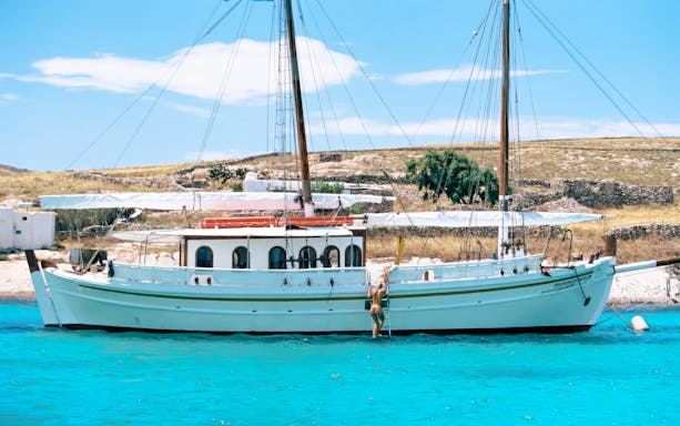 Guests swimming near a boat during a Corfu tour stop.