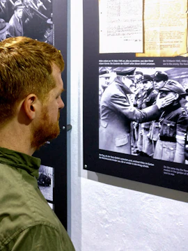 Visitor examining historical exhibit at Berlin Story Bunker.