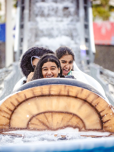 Log flume ride with smiling visitors at Lusail Winter Wonderland.