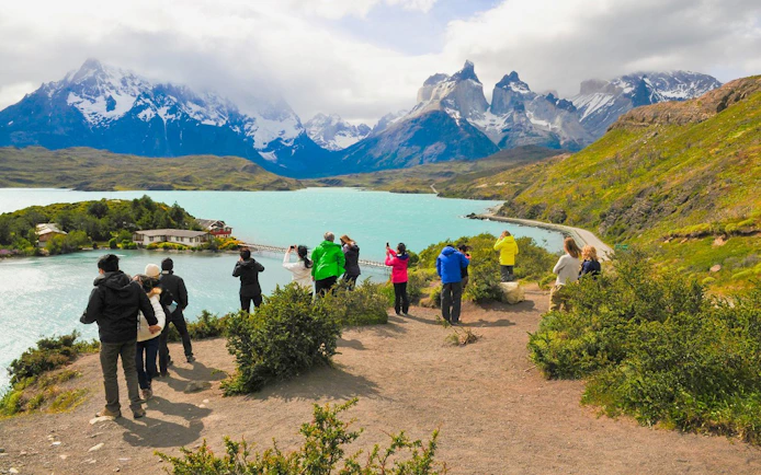 Tourist group photographing Cuernos del Paine in Torres del Paine National Park, Chile.