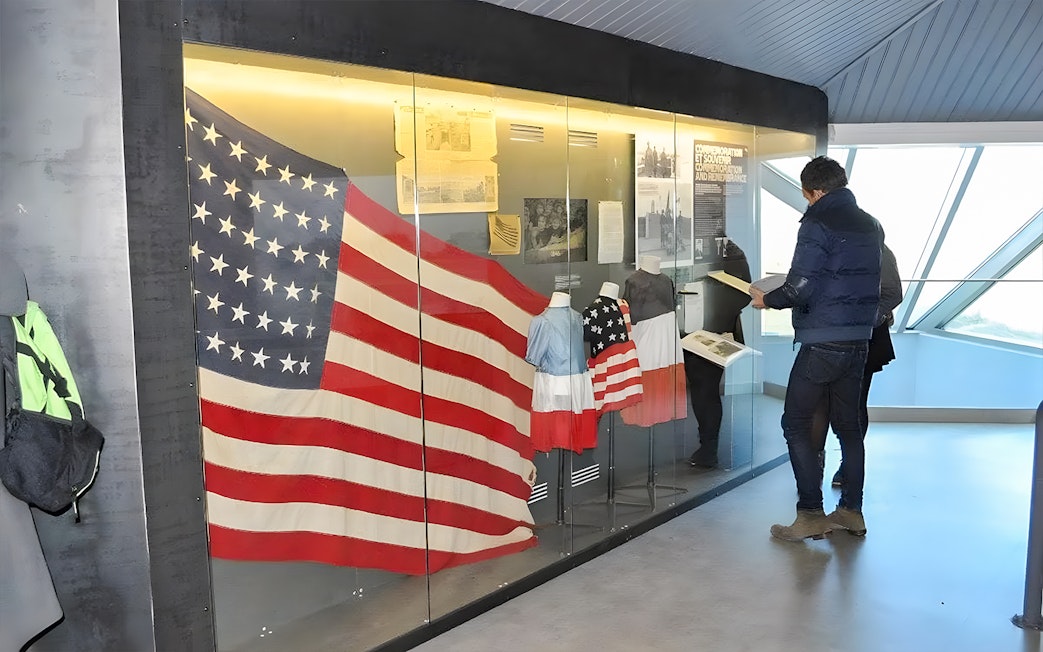 American flag display at Normandy museum exhibit, part of D-Day guided tour from Paris.
