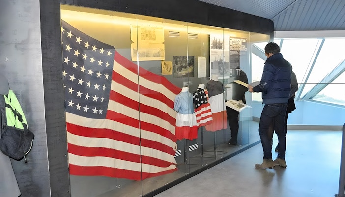 American flag display at Normandy museum exhibit, part of D-Day guided tour from Paris.