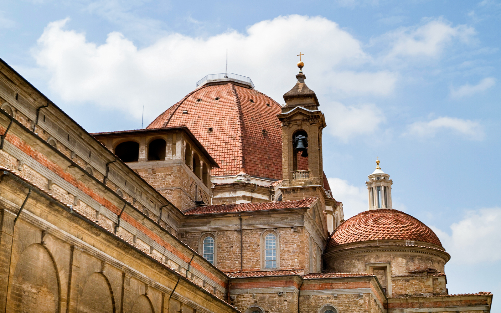 Medici Chapel exterior with red-tiled dome and bell tower in Florence, Italy.