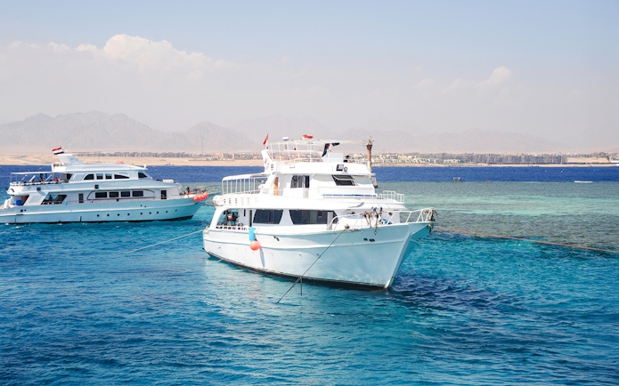 Cruise boats anchored near Tiran Island, Sharm El Sheikh, with clear blue water.