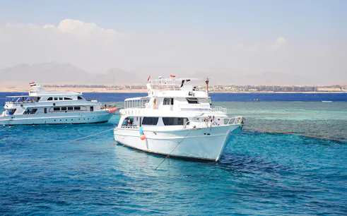Cruise boats anchored near Tiran Island, Sharm El Sheikh, with clear blue water.