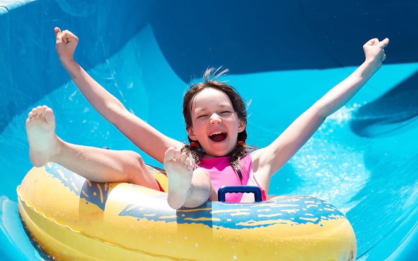 Child enjoying a water slide at Bayou Lagoon Water Park.