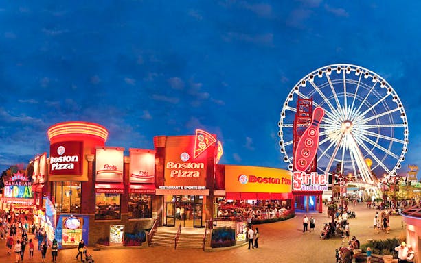 Niagara SkyWheel at night with nearby restaurants and attractions.