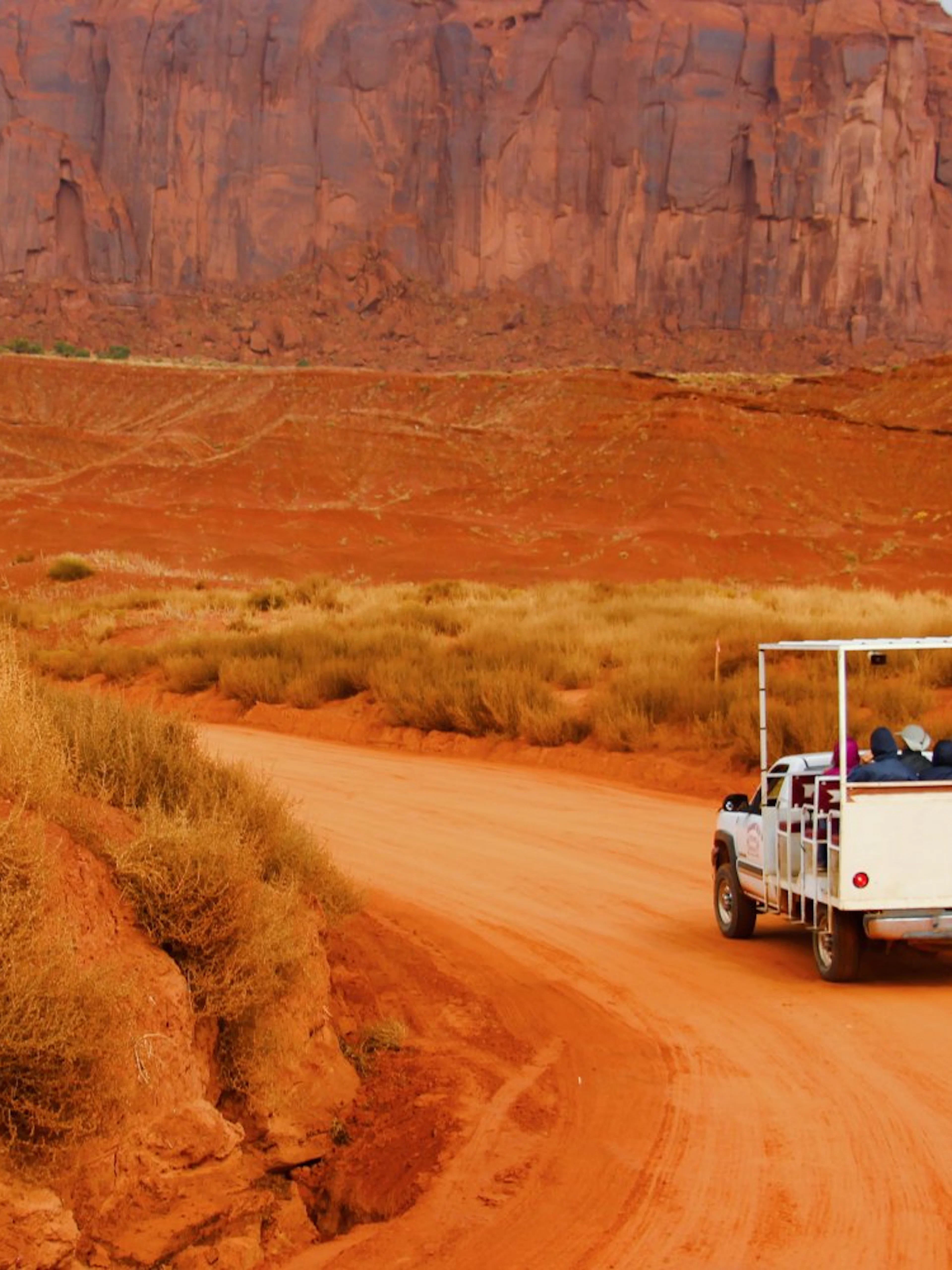 Truck on Monument Valley Loop Drive with red rock formations in the background.