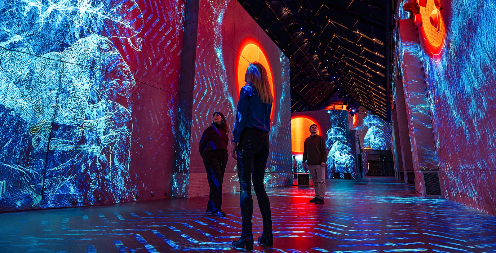 Visitors exploring digital art projections at Fabrique des Lumières.
