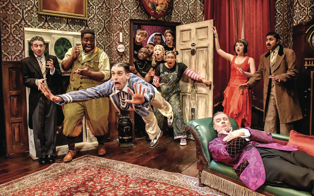 Actors in a chaotic scene from "The Play That Goes Wrong" on stage.