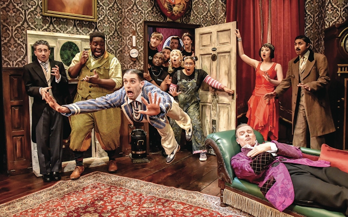 Actors in a chaotic scene from "The Play That Goes Wrong" on stage.