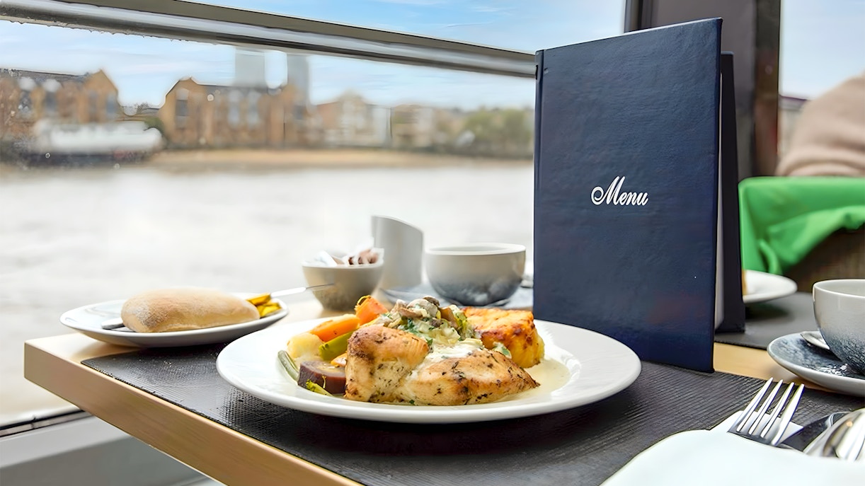 Lunch setting on Thames River Cruise with chicken dish, vegetables, and menu.