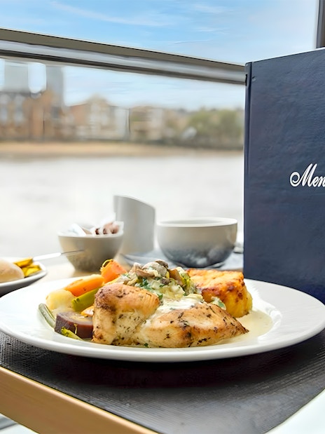 Lunch setting on Thames River Cruise with chicken dish, vegetables, and menu.