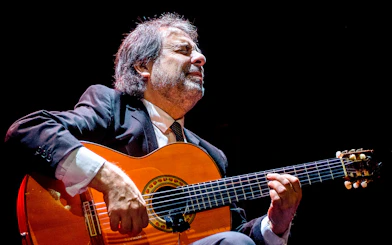 Flamenco guitarist performing at Emociones espectáculo flamenco.