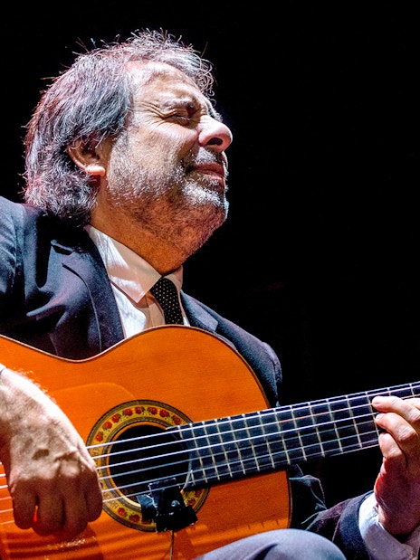 Flamenco guitarist performing at Emociones espectáculo flamenco.