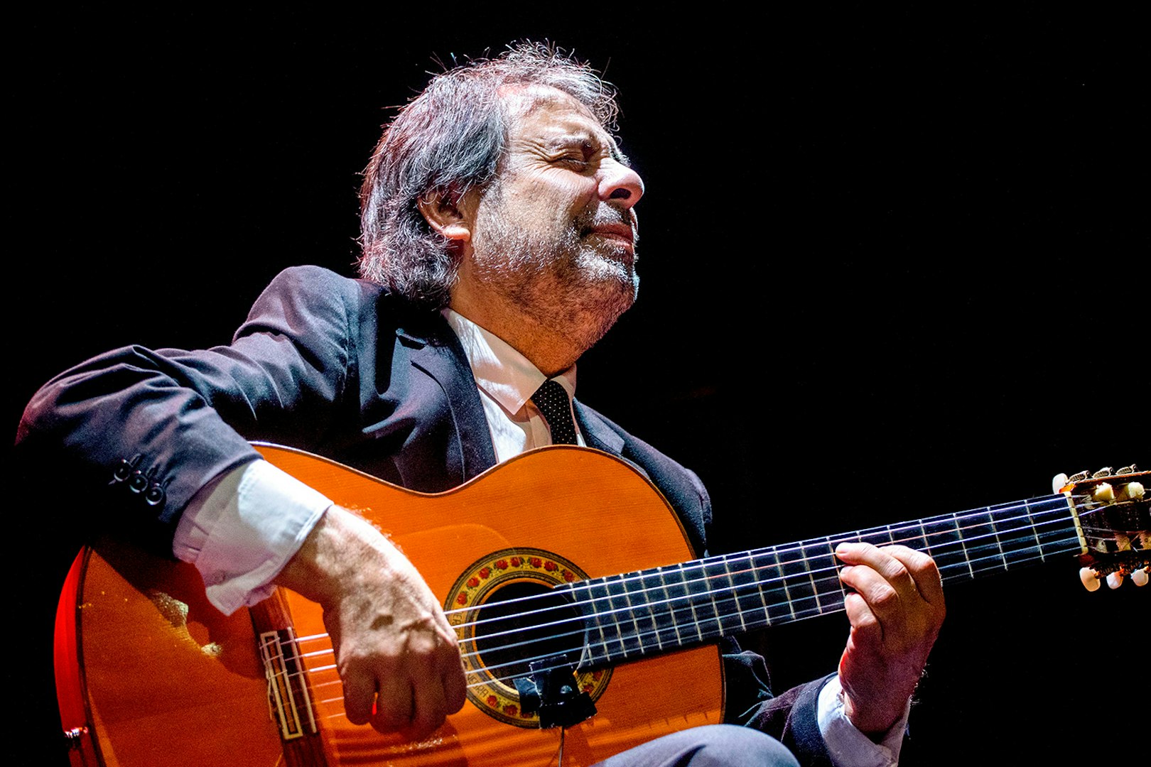 Flamenco guitarist performing at Emociones espectáculo flamenco.