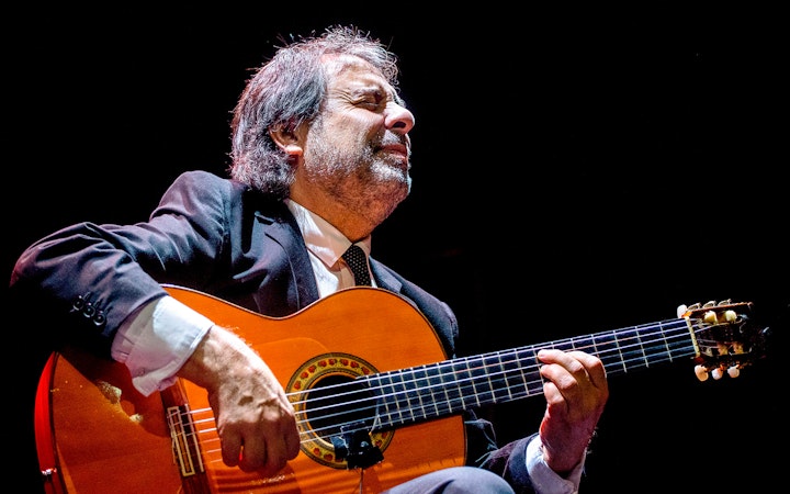 Flamenco guitarist performing at Emociones espectáculo flamenco.