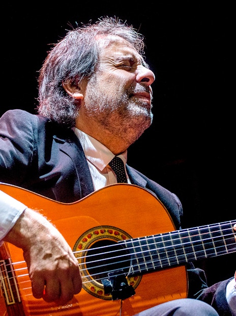 Flamenco guitarist performing at Emociones espectáculo flamenco.