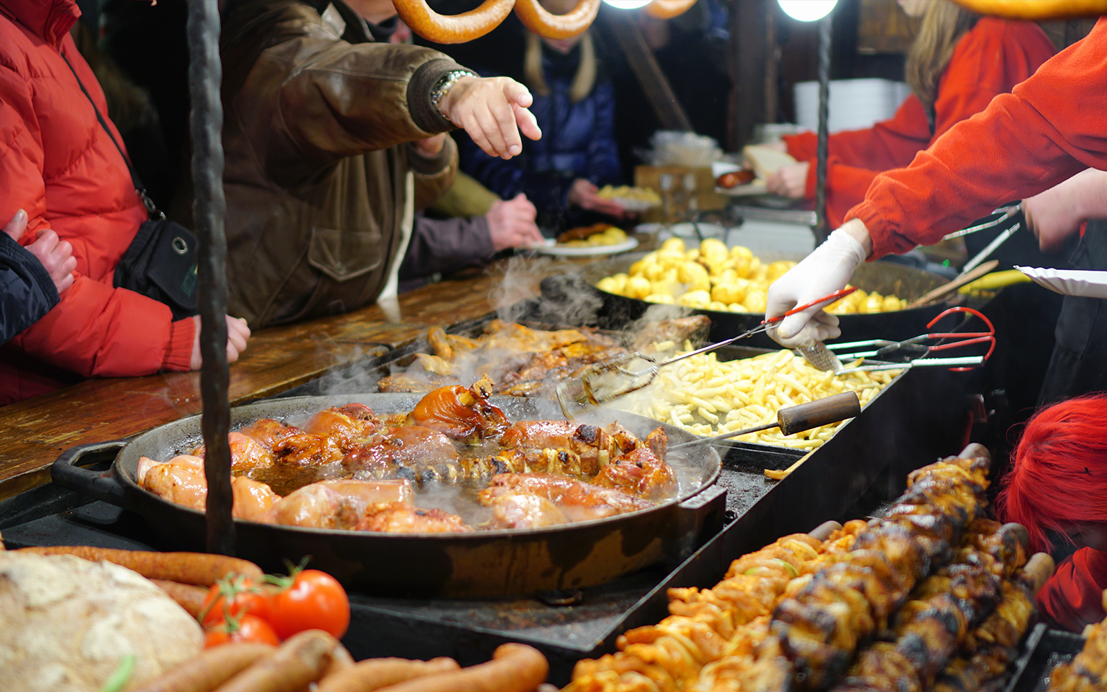 Street food vendors serving grilled meats and potatoes 