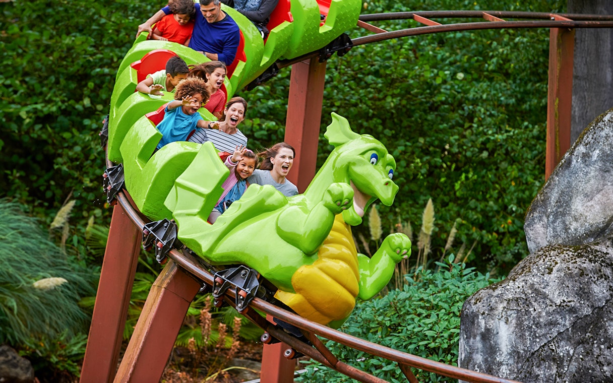 Visitors enjoying a dragon-themed roller coaster at LEGOLAND Windsor Resort.