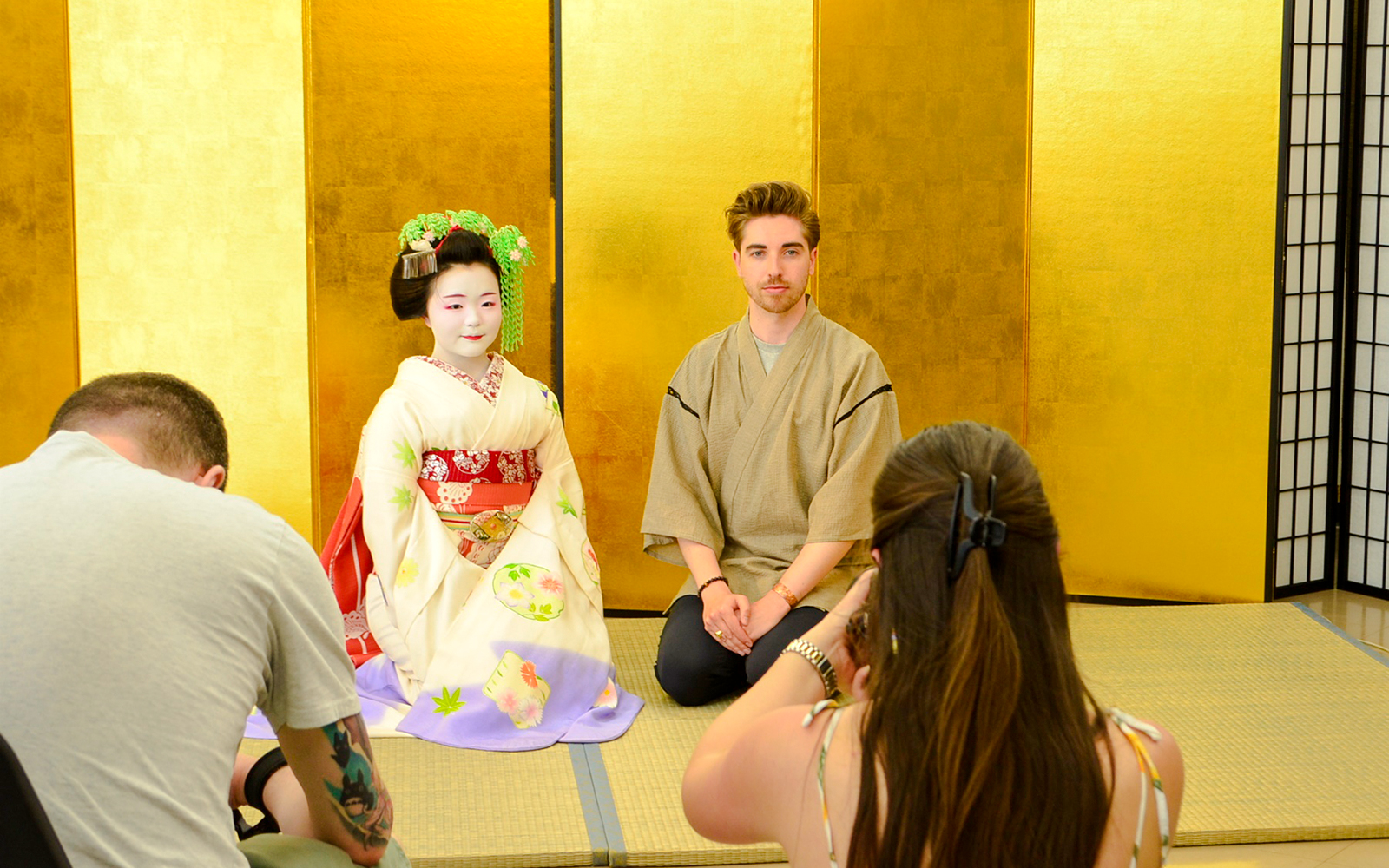 Maiko and man in traditional attire during a meet-and-greet in Japan.