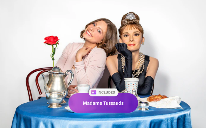 Madame Tussauds New York wax figure with visitor at a tea table.