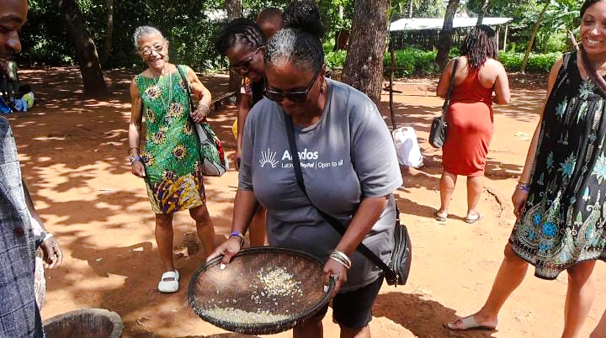 Participants engaging in traditional grain winnowing at Duruma Wedding Demo Village, Diani Beach.