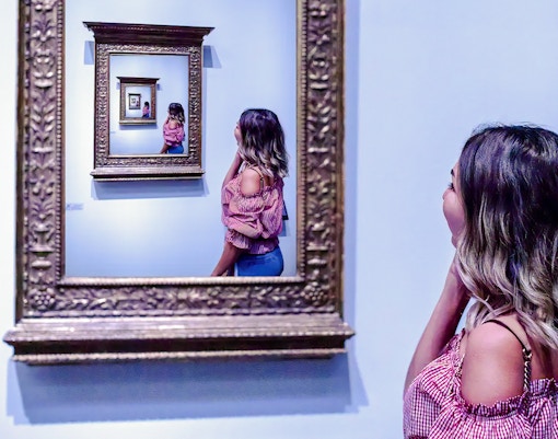 Guest observing an infinite mirror illusion at the World of Illusions.