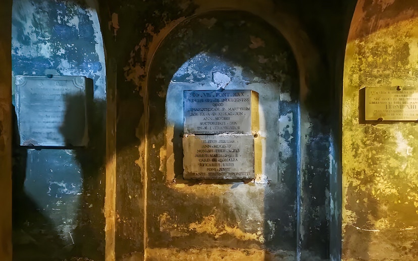 Ancient inscriptions on the walls of the Roman Catacombs during a guided tour from Rome.