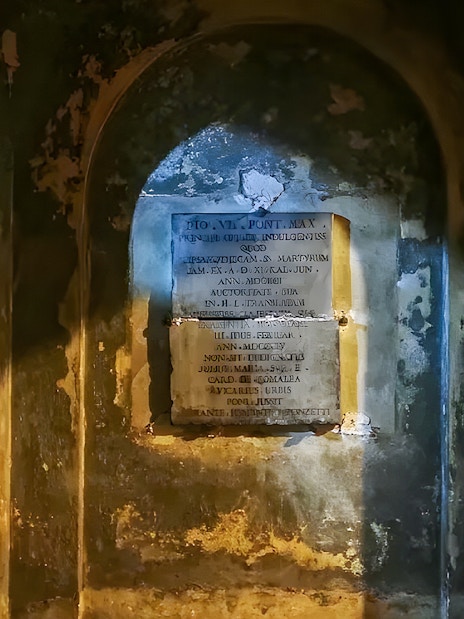 Ancient inscriptions on the walls of the Roman Catacombs during a guided tour from Rome.