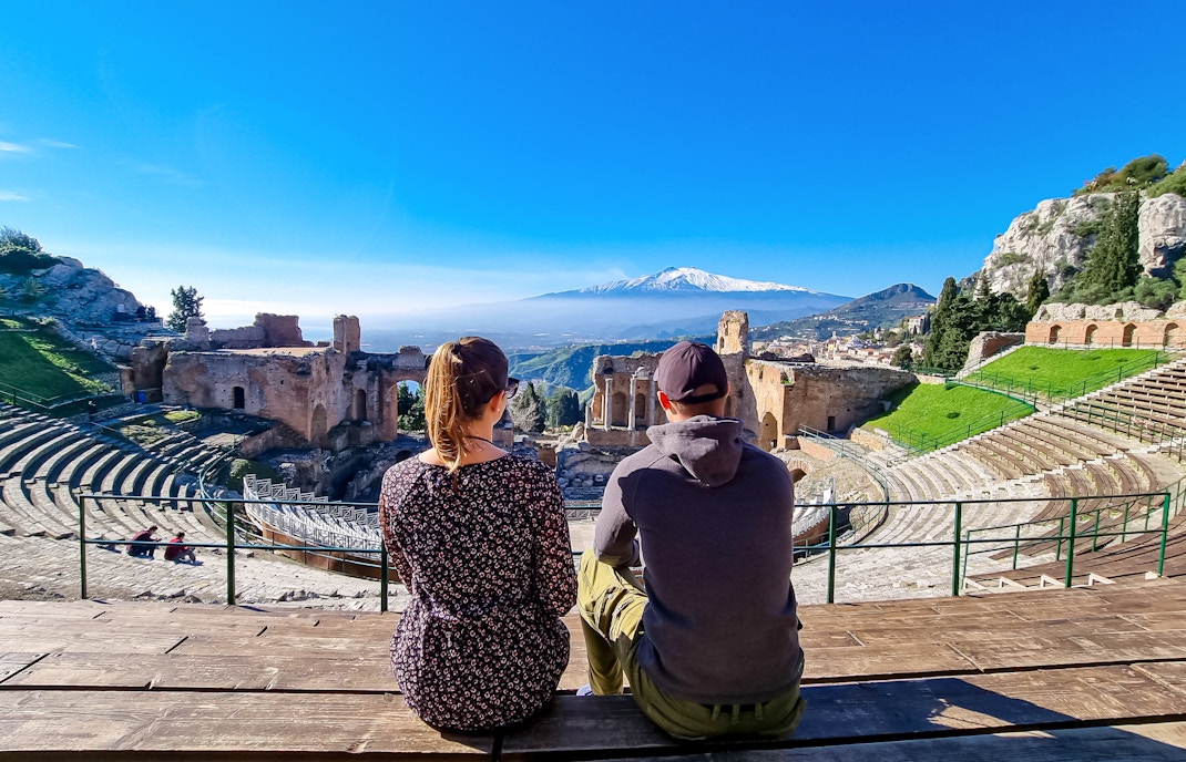 Couple sitting and enjoying the view at Taormina ancient theatre