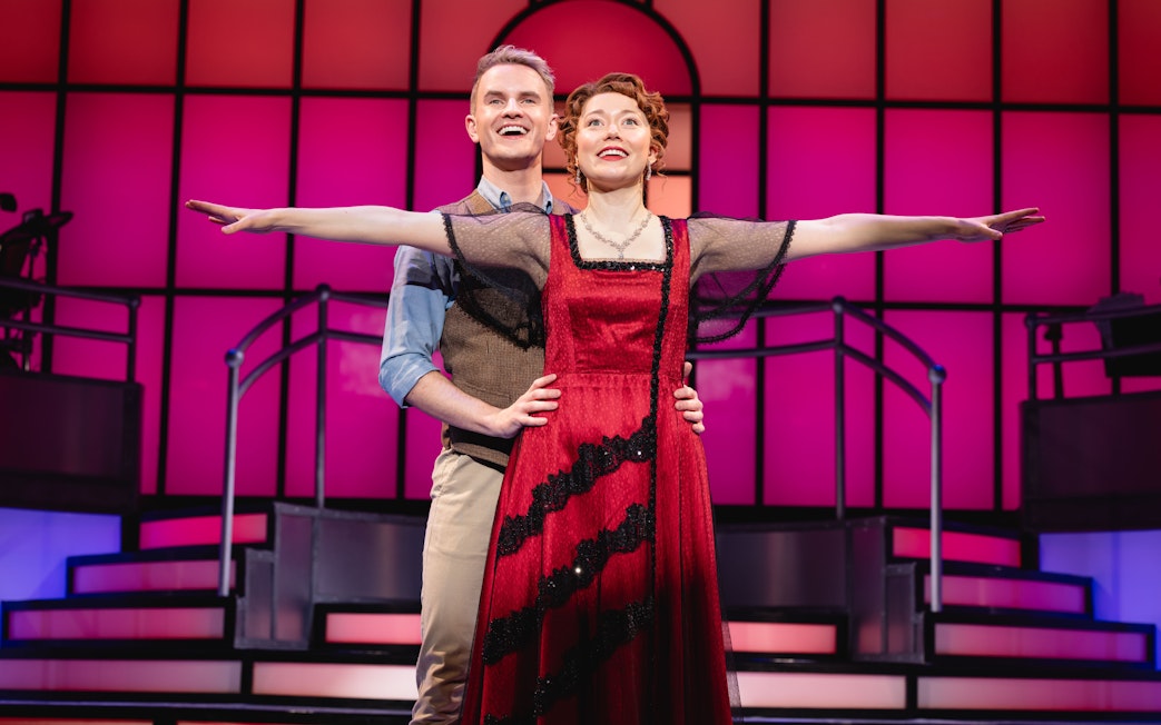 Stage performance of Titanique Westend with actors in embrace on a vibrant set.