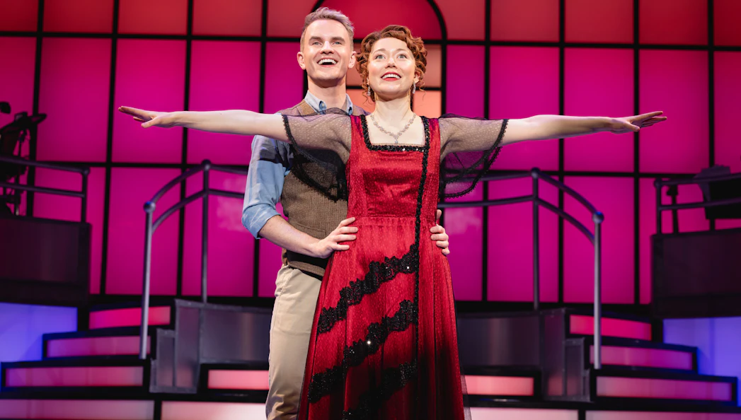 Stage performance of Titanique Westend with actors in embrace on a vibrant set.