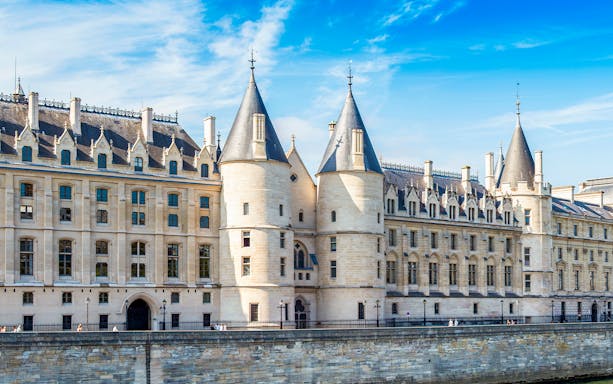 Conciergerie museum exterior with towers in Paris, France.