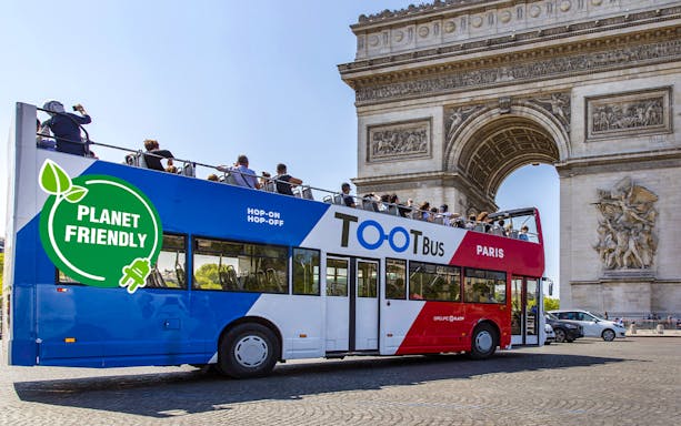 Open-top Tootbus passing by the Arc de Triomphe in Paris on a hop-on hop-off tour.