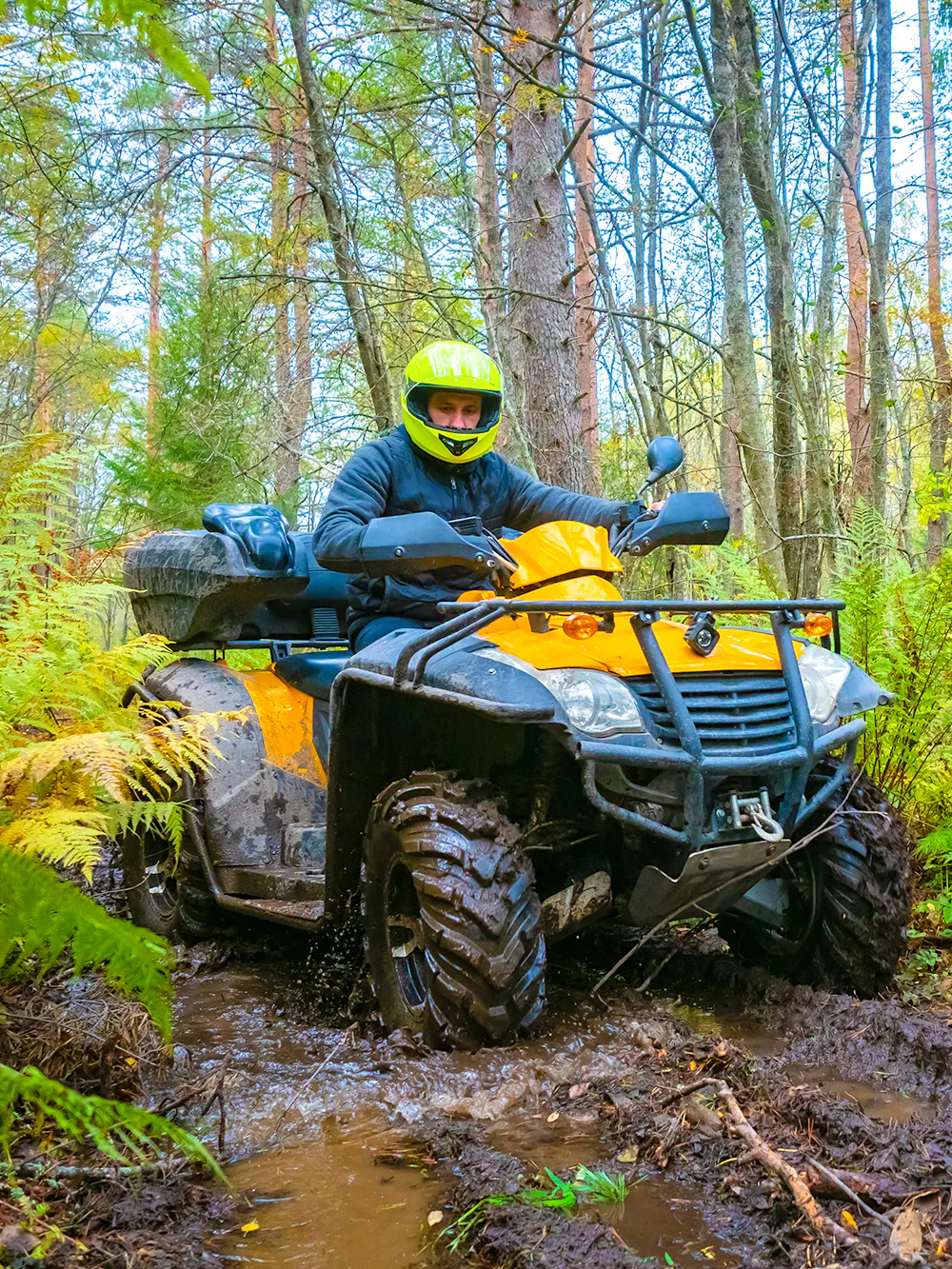 Quad biking through a muddy forest trail in Bali.