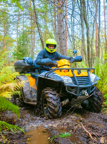 Quad biking through a muddy forest trail in Bali.