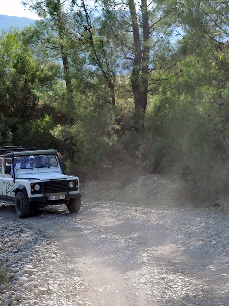 Jeep driving on a rocky trail through a forest in Antalya during a guided safari tour.