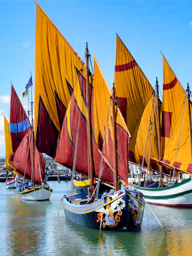 Sailing boats with colorful sails at Presepe della Marineria, Cesenatico, Italy.