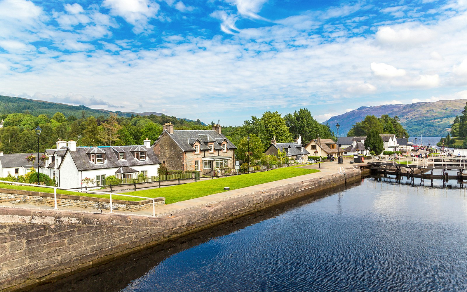 Fort Augustus, Scotland, with canal, historic buildings, and lush greenery.