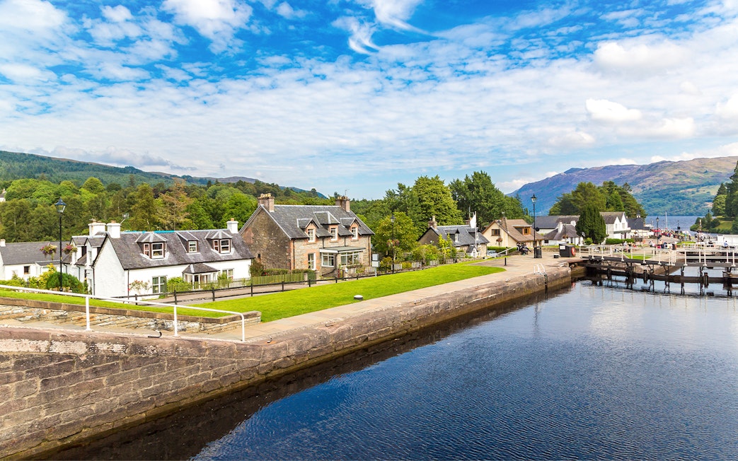 Fort Augustus, Scotland, with canal, historic buildings, and lush greenery.