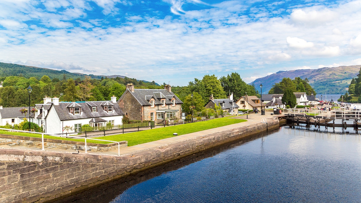 Fort Augustus, Scotland, with canal, historic buildings, and lush greenery.