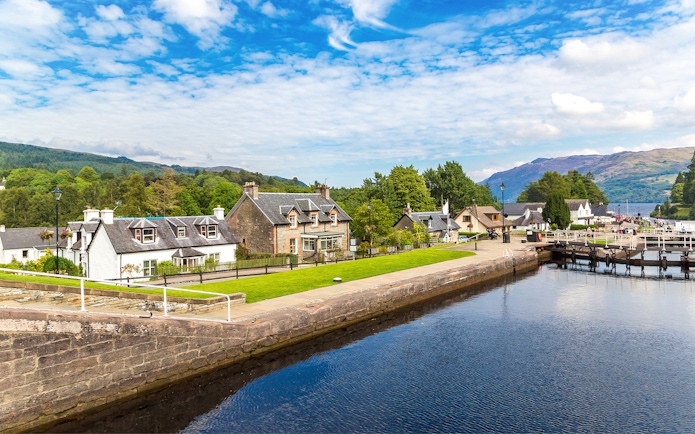 Fort Augustus, Scotland, with canal, historic buildings, and lush greenery.